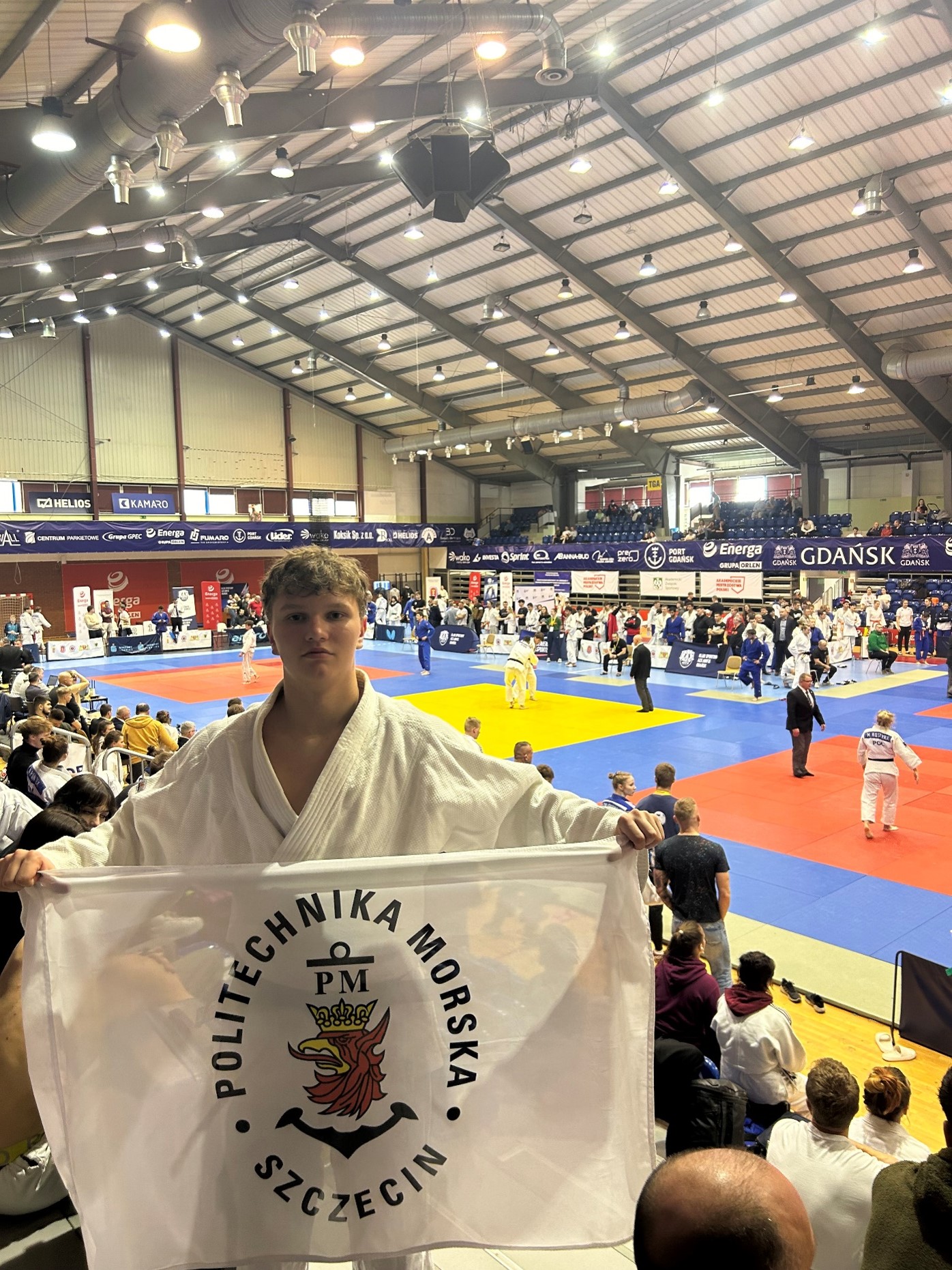 Student PM na AMP w JUDO z flagą PM 