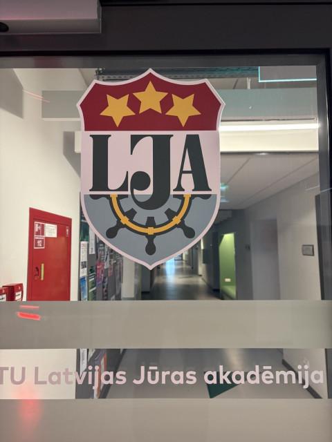 Wnetrze budynku uczelni Latvijas Jūras akadēmija z logo uczelni 