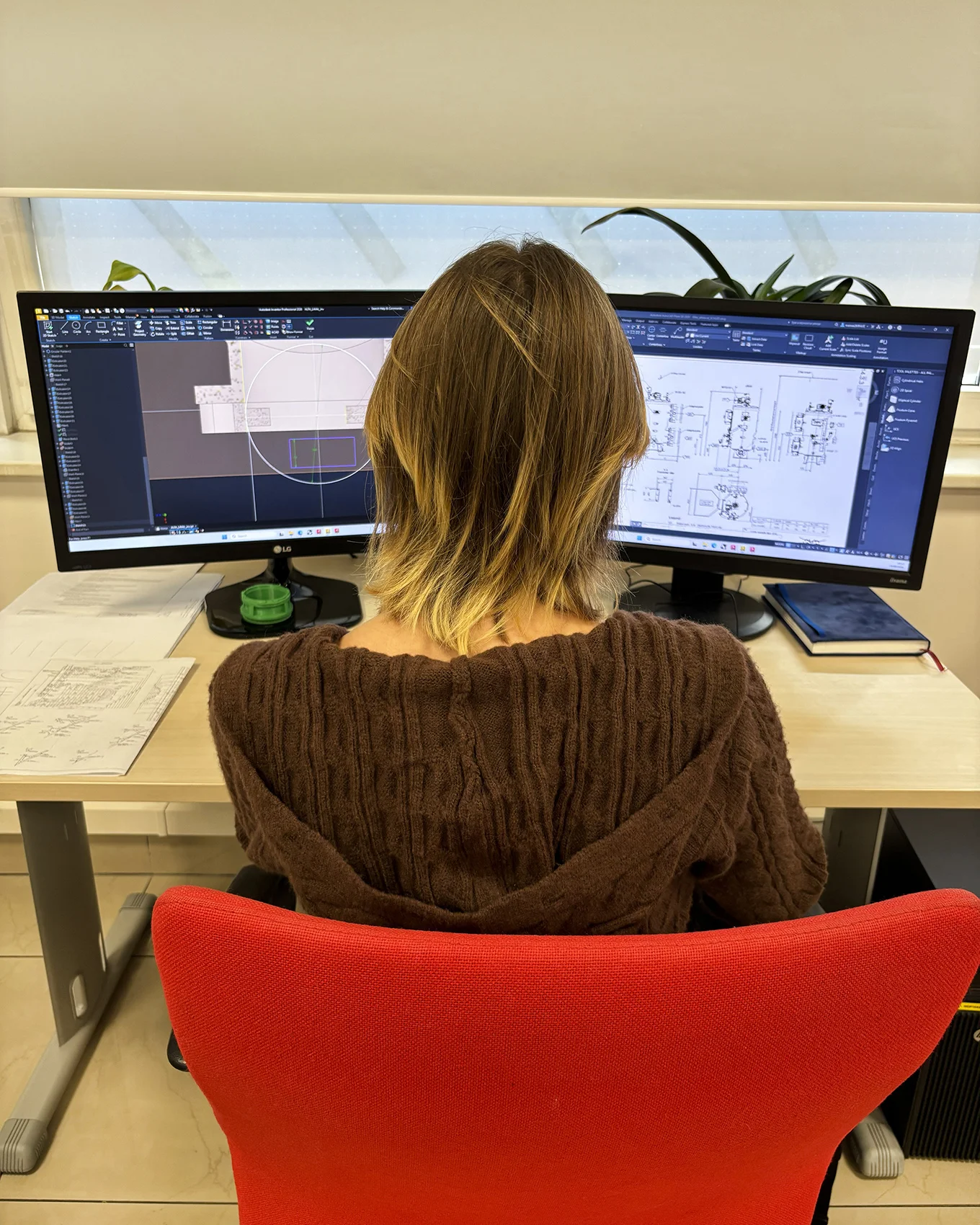 Studentka inzynierii modelowania przestzrennego przy monitorze z modelami 3D
