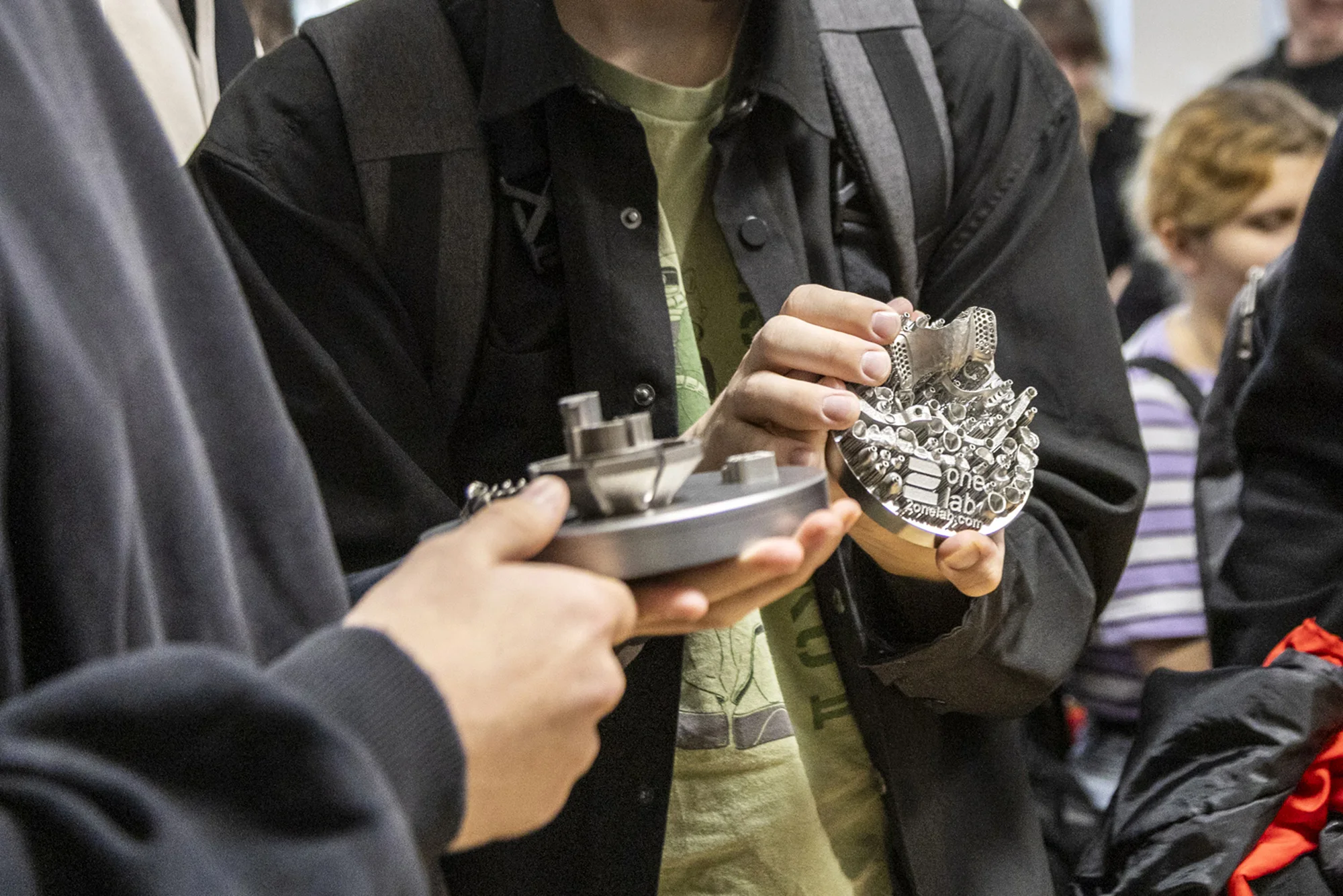 Studenci oglądają wydruki 3D z metalu