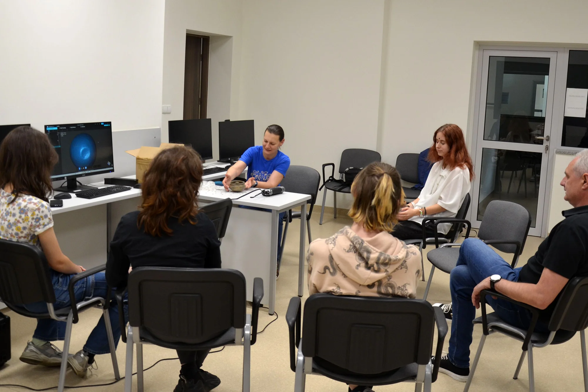 Uczestnicy spotkania siedzą przy stole i dyskutują