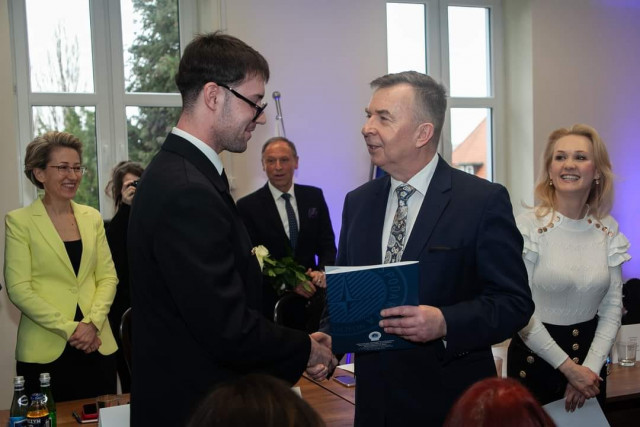 Jakub Ślęczka odbierający gratulacje od Ministra nauki Dariusza Wieczorka