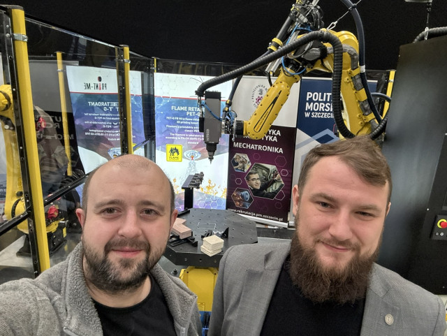 dr inż. Karol Miądlicki i dr inż. Paweł Herbin przy zrobotyzowanym stanowisku do obróbki hybrydowej addytywno-ubytkowej.