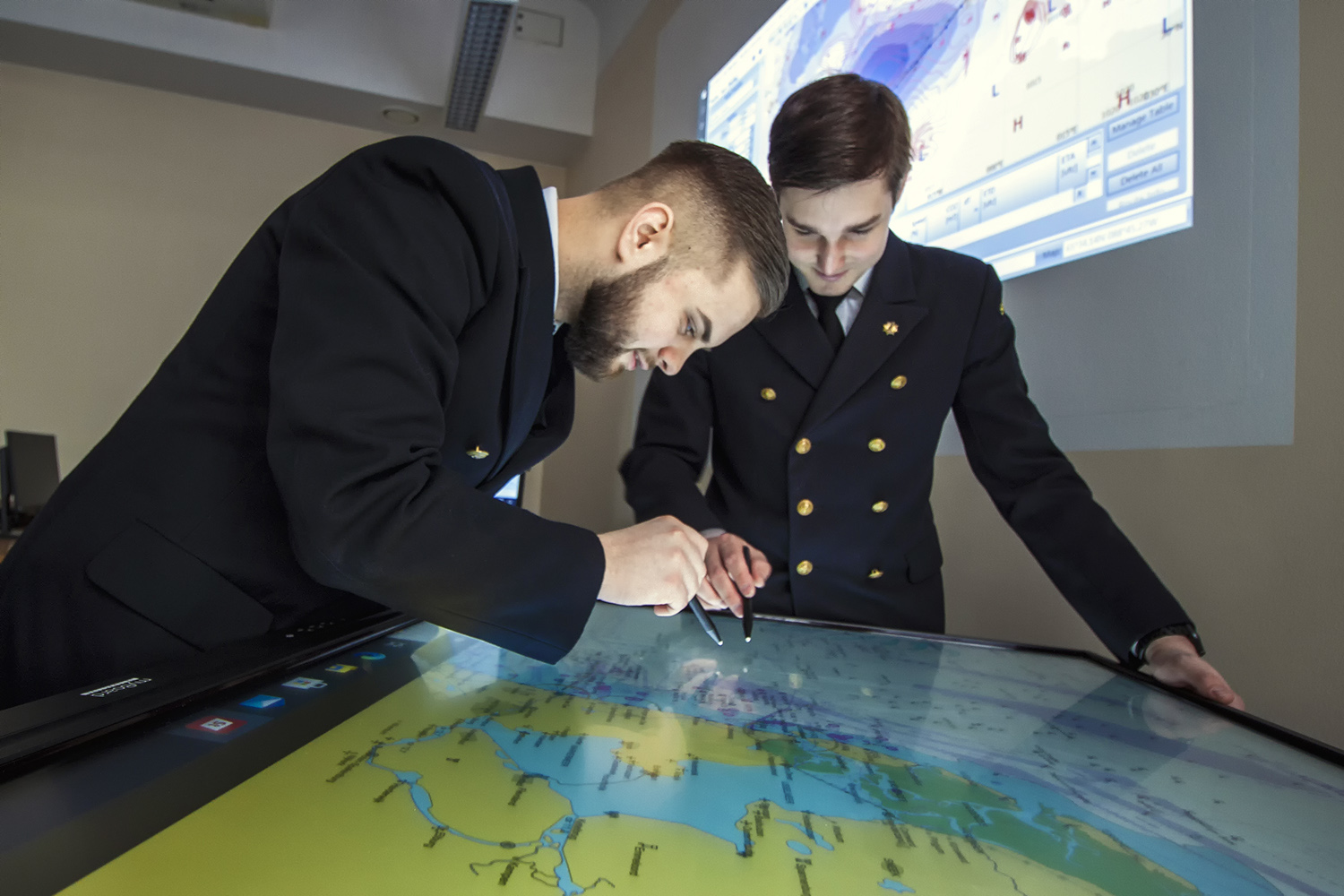 Studenci nawigacji na PM przy stole nawigacyjnym