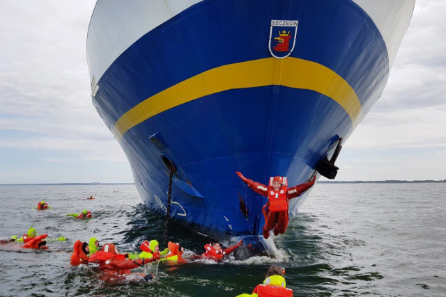 Studenci PM pływają w skafandrach przy m/s Nawigator XXI podczas praktyki przygotowawczej