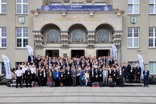 Uczestnicy konferencji TransNav 2025 - zdjęcie grupowe przed budynkiem UMG