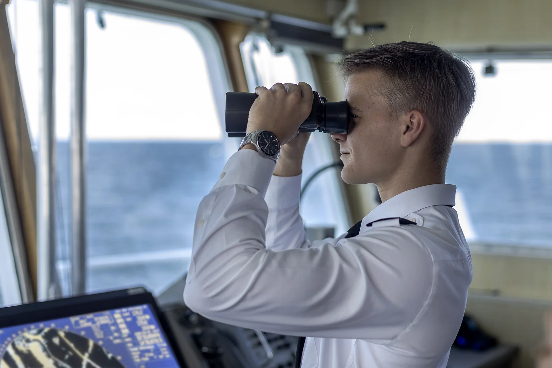 Student patrzy przez lornetkę na mostku nawigacyjnym statku Nawigator XXI