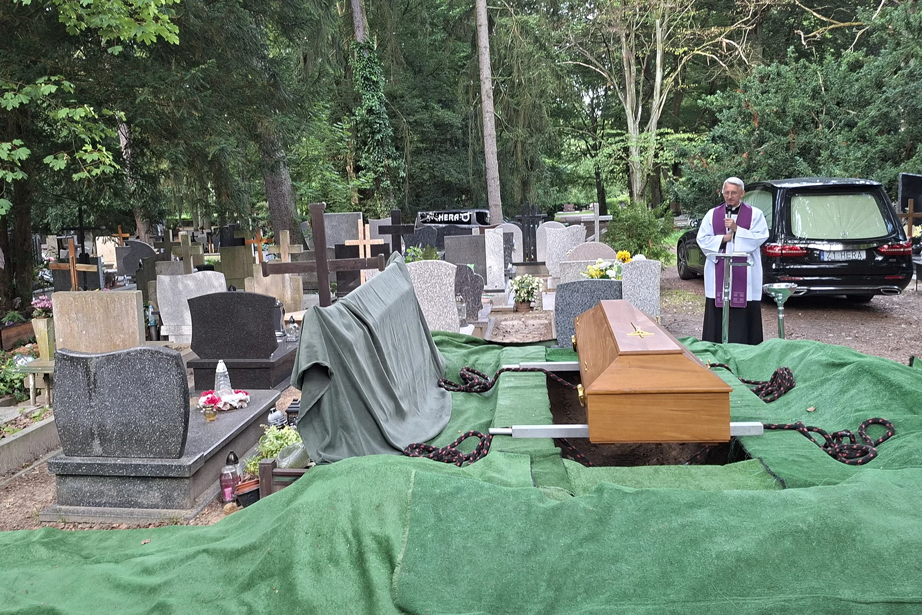 Ksiądz nad trumną kpt. Józefa Kochmańskiego na cmentarzu podczas pogrzebu