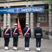 Studenci z Kompanii Honorowej i Pocztu Sztandarowego PM wraz z dowódcą stoją przed budynkiem PM na Wałach Chrobrego