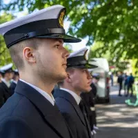 Studenci z Kompanii Honorowej PM stoją w dwuszeregu przed budynkiem PM na Wałach Chrobrego