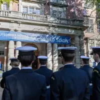 Studenci z Kompanii Honorowej PM stoją w dwuszeregu przed budynkiem PM na Wałach Chrobrego - widok od ulicy