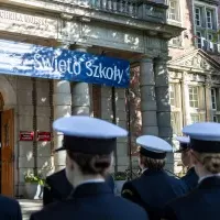 Studenci z Kompanii Honorowej PM stoją w dwuszeregu przed budynkiem PM na Wałach Chrobrego - widok od ulicy
