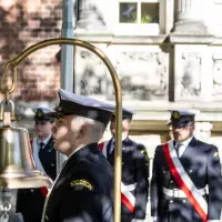 Studenci z Kompanii Honorowej PM przygotowują się wciągnięcia na maszt banderę przed budynkien uczelni z okazji Święta Szkoły