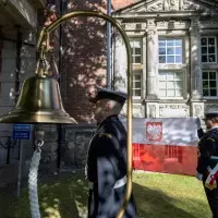 Studenci z Kompanii Honorowej PM wciągają na maszt banderę przed budynkien uczelni z okazji Święta Szkoły
