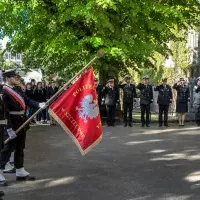 Kompania Honorowa PM z pocztem sztandarowym i dowódcą oraz pracownicy PM podczas uroczystości  wciągnięcia bandery przy budynku uczelni z okazji Święta Szkoły 