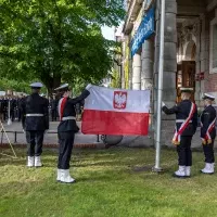 Studenci z Kompanii Honorowej PM prezentują banderę przed budynkiem uczelni w dniu Święta Szkoły