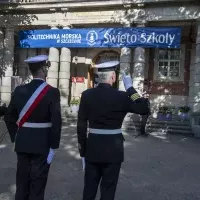 Kompania Honorowa PM z pocztem sztandarowym i dowódcą oraz pracownicy PM podczas uroczystości  wciągnięcia bandery przy budynku uczelni z okazji Święta Szkoły 