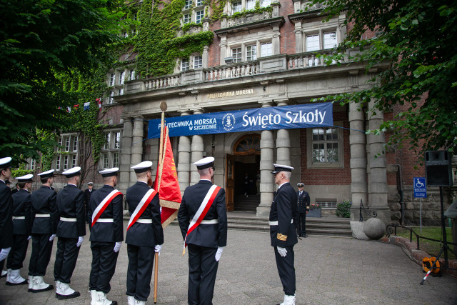 Studenci z Kompanii Honorowej i Pocztu Sztandarowego PM wraz z dowódcą stoją przed budynkiem PM na Wałach Chrobrego