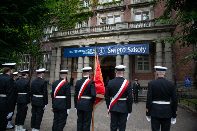 Studenci z Kompanii Honorowej i Pocztu Sztandarowego PM wraz z dowódcą stoją przed budynkiem PM na Wałach Chrobrego