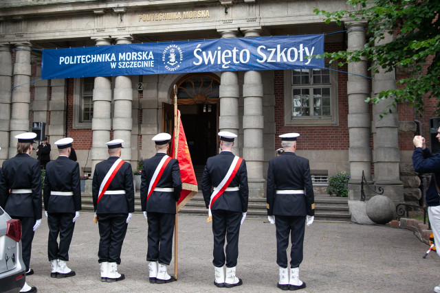 Studenci z Kompanii Honorowej i Pocztu Sztandarowego PM wraz z dowódcą stoją przed budynkiem PM na Wałach Chrobrego