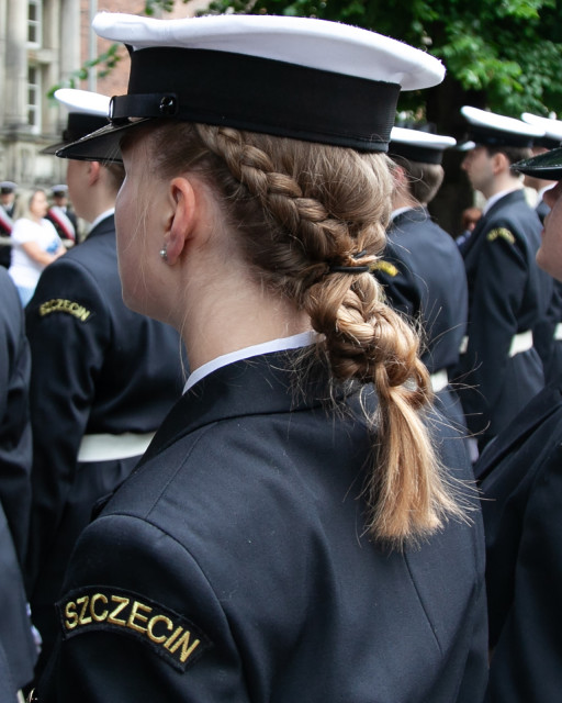 Studentka stoi w szeregu przed budynkiem PM na Wałach Chrobrrego