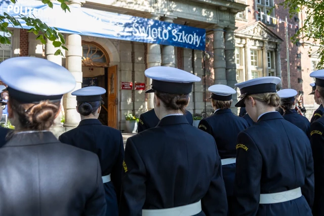 Studenci z Kompanii Honorowej PM stoją w dwuszeregu przed budynkiem PM na Wałach Chrobrego - widok od ulicy