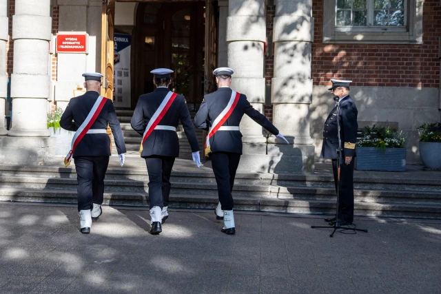 Poczet Sztandarowy Kompanii Honorowej PM wchodzi do uczelni