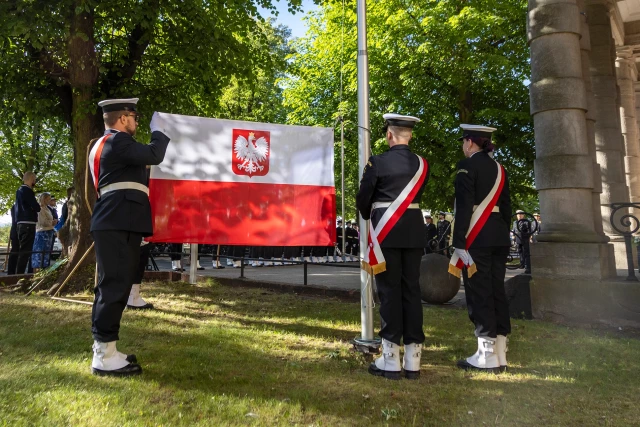 Studenci z Kompanii Honorowej PM prezentują banderę przed budynkiem uczelni w dniu Święta Szkoły