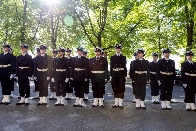 Studenci z Kompanii Honorowej PM stoją w dwuszeregu przed budynkiem PM na Wałach Chrobrego