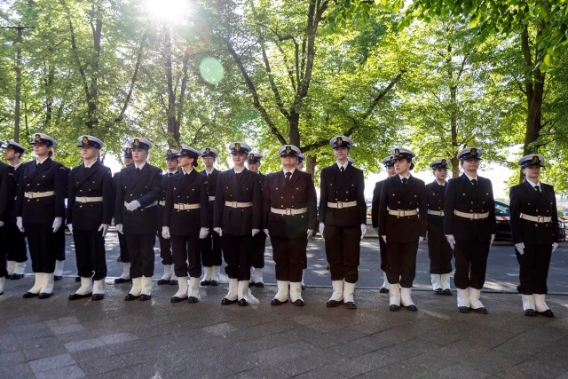 Studenci z Kompanii Honorowej PM stoją w dwuszeregu przed budynkiem PM na Wałach Chrobrego