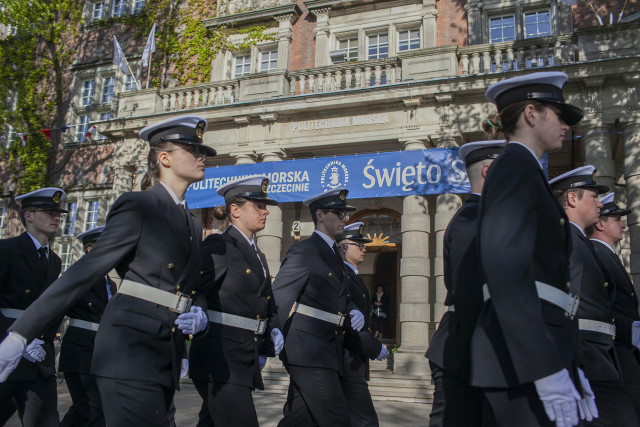 Kompania Honorowa PM maszeruje przed głównym wejściem do uczelni